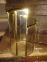 Full view of glass and brass organizer showing hexagonal shape and partitions