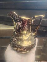 Front view of copper lustre jug showing overall form and relief decoration