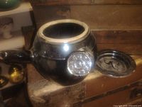 Top view of black glazed bean crock showing open mouth and lid