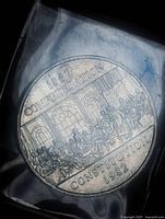 Reverse of 1982 Constitution dollar showing Confederation scene and legends