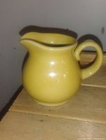 Front view of yellow ceramic cream pitcher