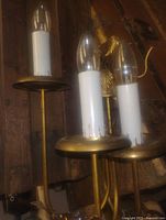 Front view showing three candle sockets and brass finish