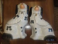 Front view of both Staffordshire spaniel figurines on table