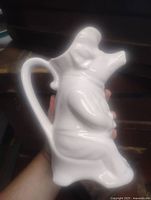 right side view of white ceramic pig pitcher showing handle and spout