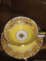 overhead view of cup nested in saucer showing yellow band and gold floral pattern