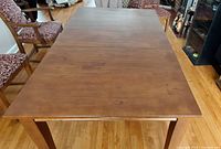 Top view of rectangular solid maple table with center expansion leaf inserted