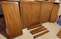 tabletop panels and legs of solid maple dining table leaning against wall