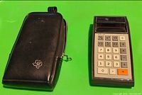 Front view of calculator beside carrying case