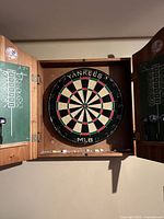 Interior view showing dartboard, scoreboards, darts and chalk shelf