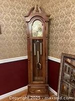 Full view of the wooden grandfather clock against wall