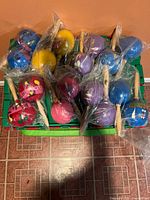 Top view of all eight poly-bagged maracas showing assorted colors