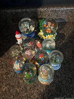 All 11 mini snow globes grouped on countertop