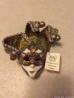 Front view showing entire mask, bells, pearls and tag