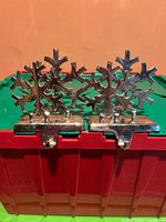Front view of the two silver-tone snowflake stocking holders