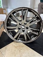 Front face of one 19" Tesla Model S rim showing spoke pattern and curb rash