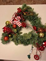 Full view of artificial wreath showing decorations and plug
