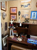 Overall view of desk, masks, wall art and decor