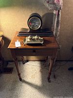 Side table with mantel clock on top and inkwell resting on table