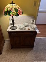 Front view of cabinet, lamp and decor on marble top