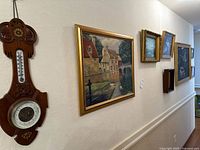 Overall wall view showing barometer and multiple framed artworks