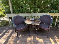 Full set on deck showing table, two chairs, plant
