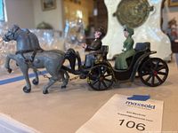 Full view of hand-painted cast iron horse and carriage figurine with passengers