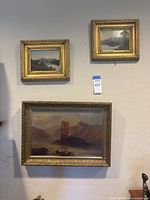 All three paintings hanging on wall showing relative sizes and gold frames