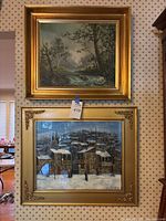 Overall view showing both framed oil paintings, landscape on top and winter cityscape below