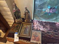 Lot overview showing two carved figures and three framed icons