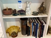 Two shelves showing books, glass bowl, vase, rabbit figurine, incense burner, amethyst, onyx slices, wooden bowl