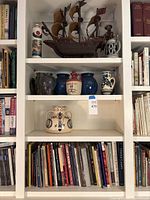 Overall bookshelf view with ship model, stoneware vessels and books