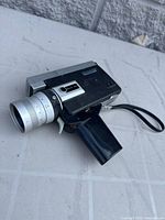 Left front view showing body, lens, pistol grip, wrist strap