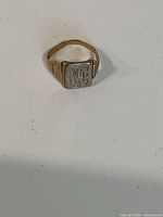 Full view of signet ring front, shows yellow band and white top with LG engraving