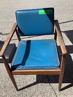 Front view of wooden armchair with blue vinyl cushions