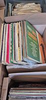 Stack of LP records in open box with visible spines and covers