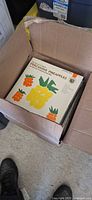 Open box showing stack of LPs, top record “Percussive Pineapples.”
