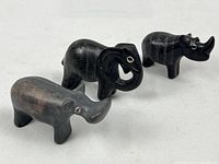 Group shot of three black soapstone animal carvings: elephant, rhino, hippo