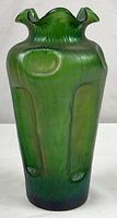 Front view of green iridescent vase showing full form and pinched sides