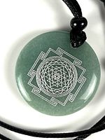 Close-up of round green pendant showing silver geometric inlay