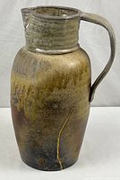 Full view of tall pottery pitcher showing glaze and overall form