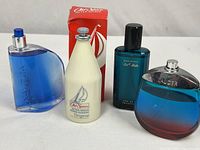 Group shot of four fragrance bottles: Nautica, Old Spice (with box), Davidoff Cool Water, Estée Lauder