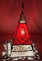 Lamp illuminated showing red sheepskin panels and iron frame