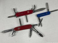 All three knives open to show tools