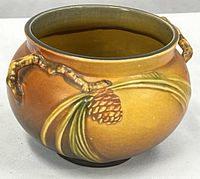 Front view showing pinecone motif and both handles