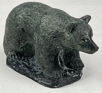 Left front view of dark green-grey bear figurine on base