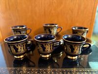Six cobalt blue Spyropoulos cups on black tray showing design