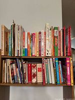 Two shelf images showing entire collection of cookbooks and magazines
