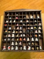 Full view of display case holding numerous thimbles