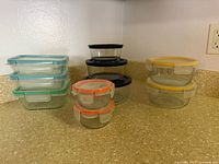Full set of glass containers stacked by lid color; shows quantity, shapes, lid colors and condition
