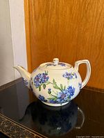 Left side view of Spode floral teapot on reflective surface